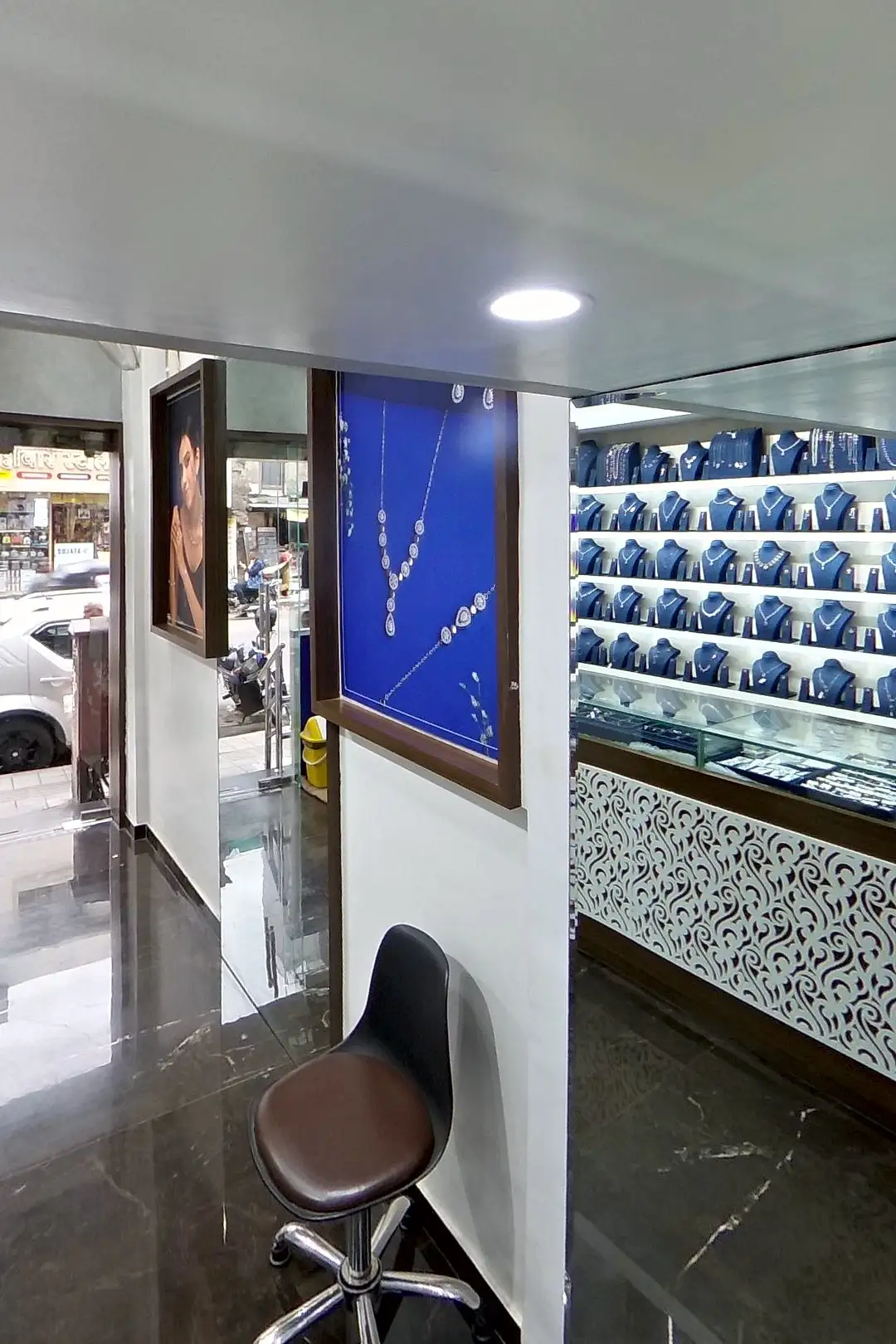 Inside a jewellery store: bridal sets and idols, gold-finish sets on blue busts along lit white shelves