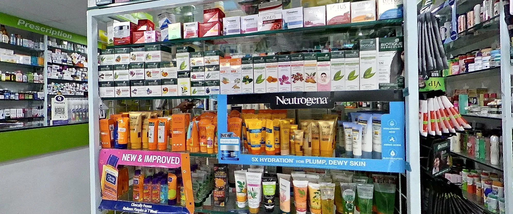 A pharmacy's skin-care aisle: face washes, sunscreens and creams on glass shelves